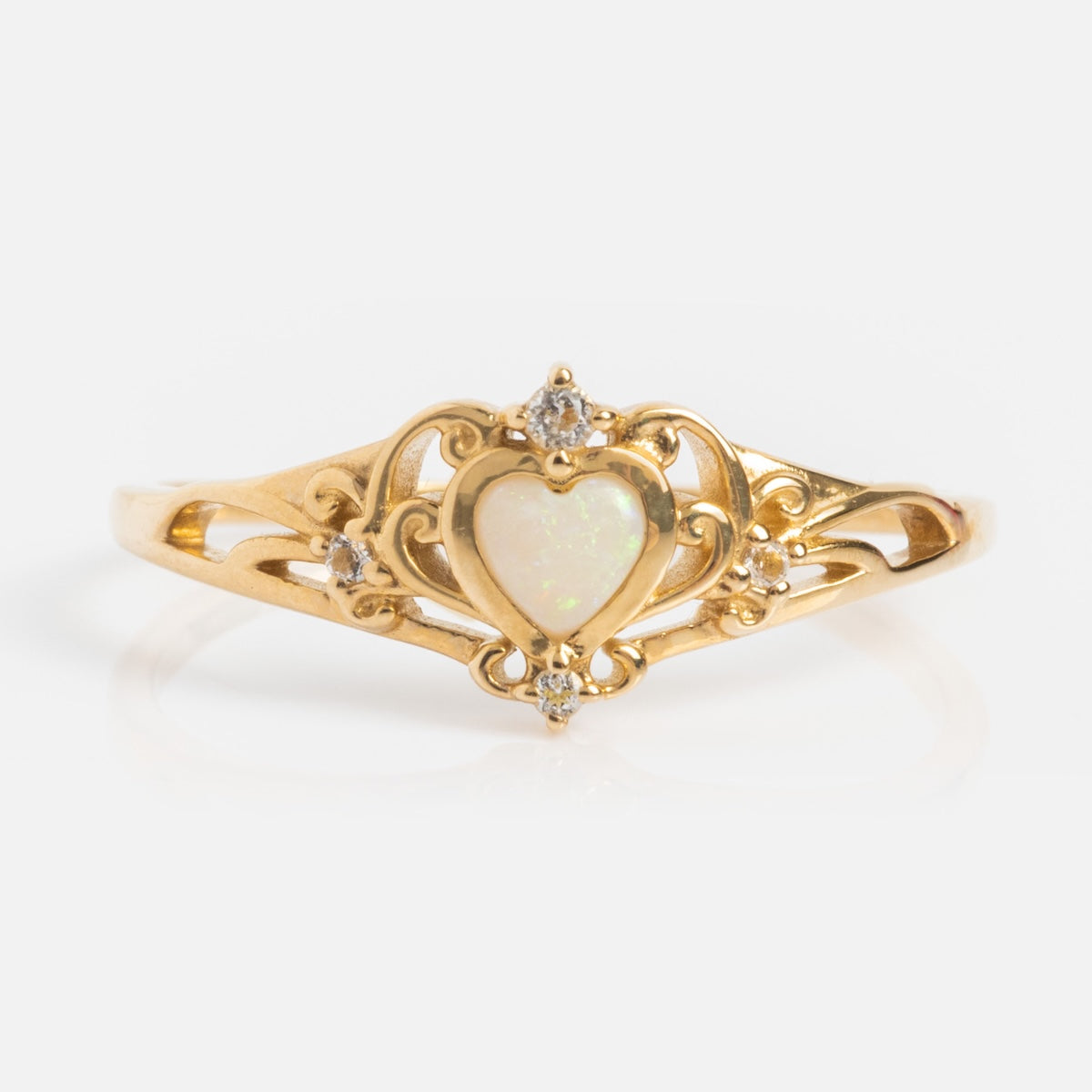 The Solid Gold Openwork Filigree Opal Heart Ring features ornate filigree with a central Australian opal, accented by small round diamonds on the top, sides, and bottom.