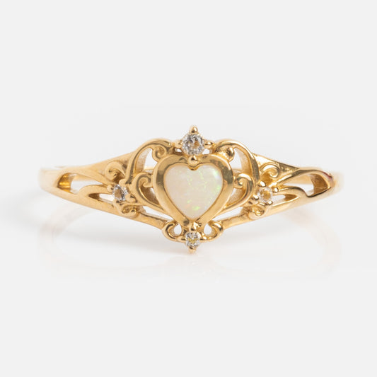 The Solid Gold Openwork Filigree Opal Heart Ring features ornate filigree with a central Australian opal, accented by small round diamonds on the top, sides, and bottom.