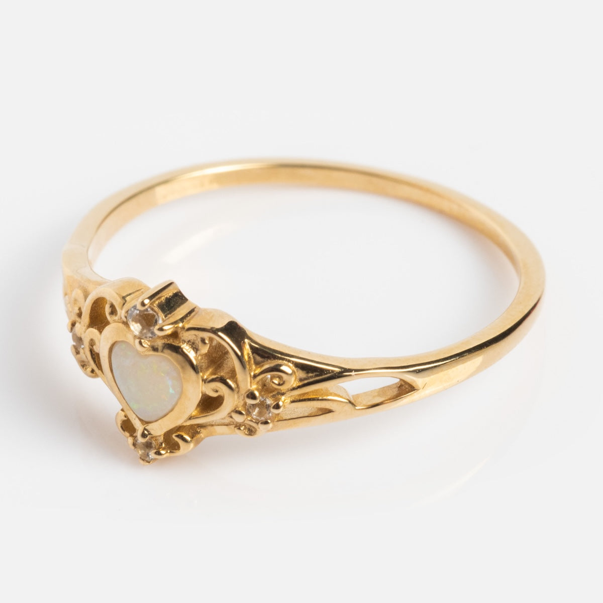 The Solid Gold Openwork Filigree Opal Heart Ring features an ornate design with a heart-shaped opal centerpiece, highlighted by intricate filigree detailing and delicate decorative accents.