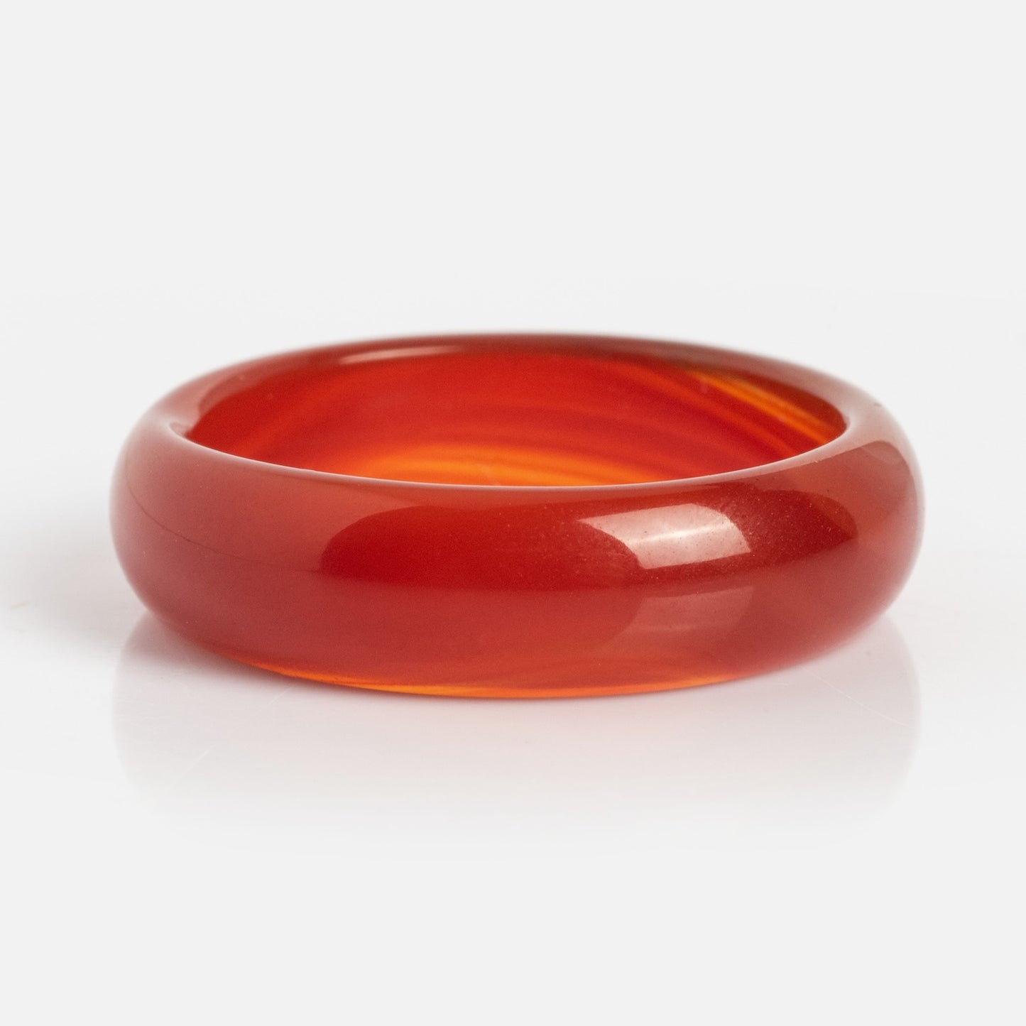 A polished, translucent Persimmon Dark Orange Agate Stone Ring with a smooth, rounded surface is shown against a plain white background.