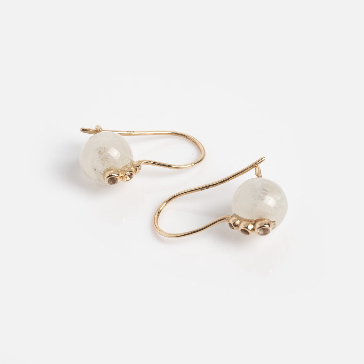 The Solid Gold Moonstone Ball Earrings Sample features round moonstone beads on gold hooks, each accented with 9k solid gold details at the base, shown against a plain white background.