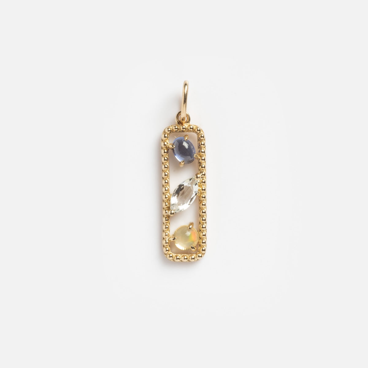 The Floating Charm Sample is a solid yellow gold rectangular pendant with beaded edges, featuring three natural gemstones—blue oval, clear marquise, and yellow round—set vertically inside.