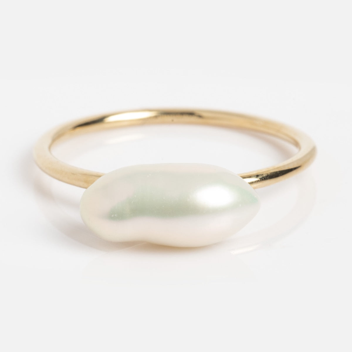 The Solid Gold Modern Pearl Solitaire Ring (sample size 7) features a single, uniquely shaped white pearl set on a slim 9k yellow gold band, shown against a plain white background.