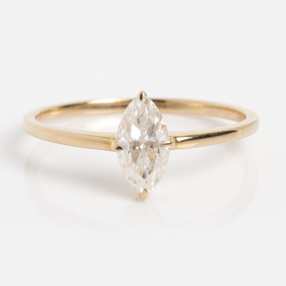 The Solid Gold Marquise Diamond Ring (Sample Size 7) features an 8mm marquise-cut lab diamond solitaire on a simple, delicate 14k yellow gold band, shown against a white background.