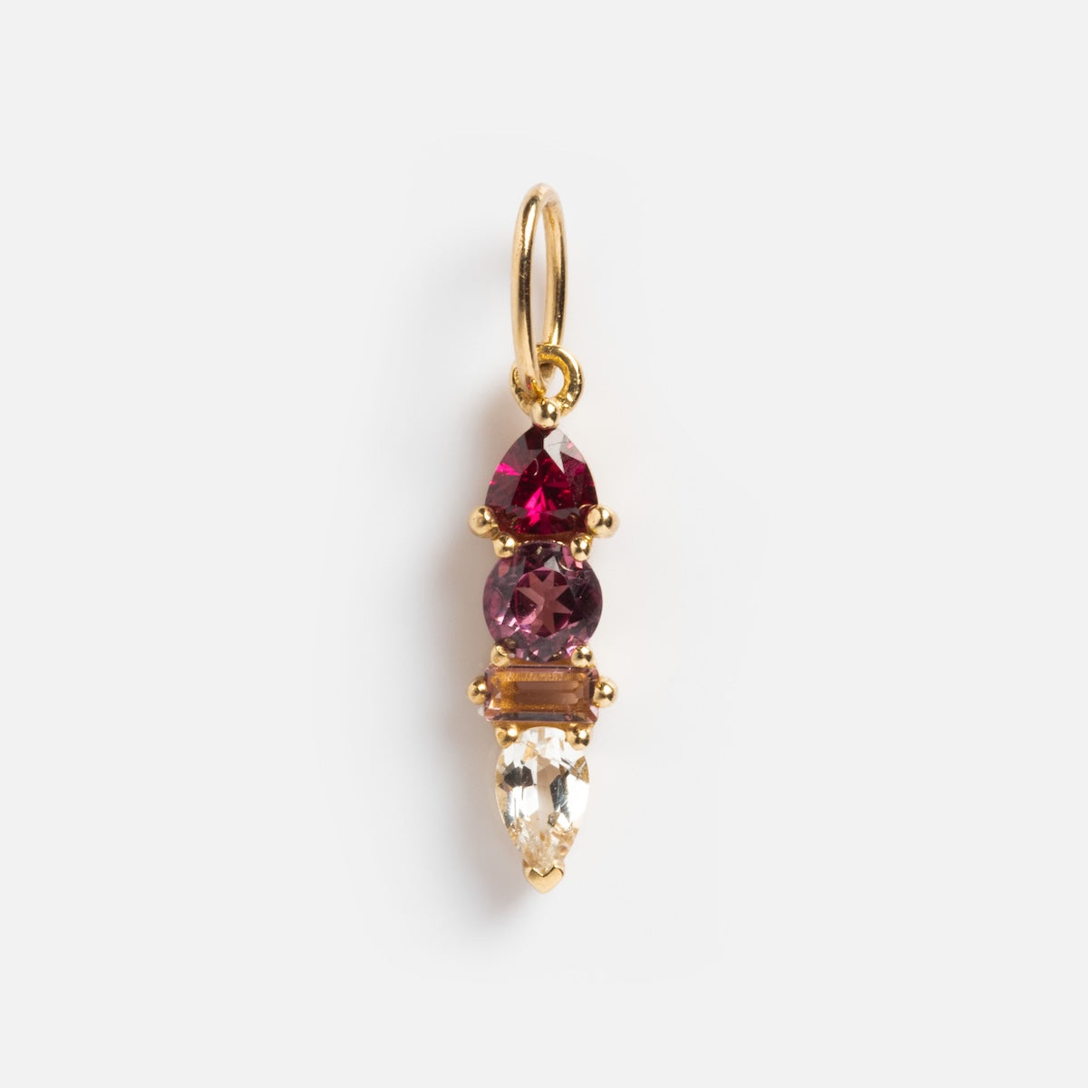 The Solid Gold Modern Ombre Birthstone Charm showcases three vertically stacked gemstones—a red teardrop, a round purple stone, and a clear teardrop—separated by a gold bar, all elegantly hanging from a gold loop.