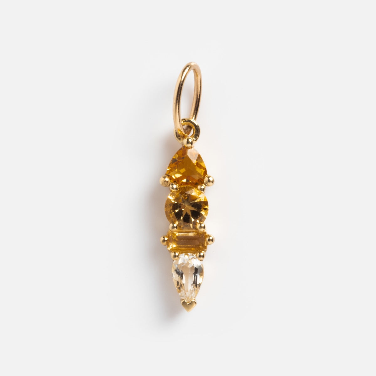 The Solid Gold Modern Ombre Birthstone Charm is a gold earring with three stacked yellow and amber gemstones, each in a unique cut, hanging from a small gold hoop.