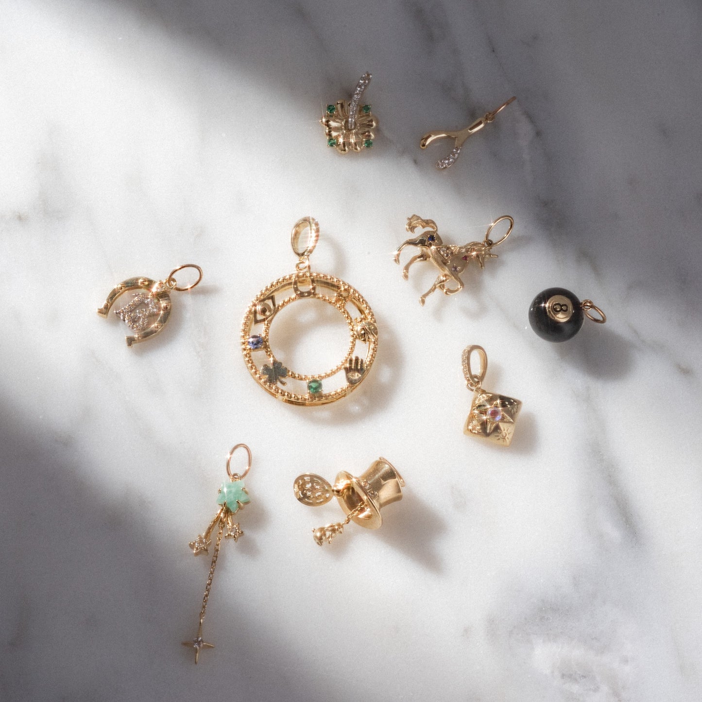 Gold jewelry pendants on a marble surface