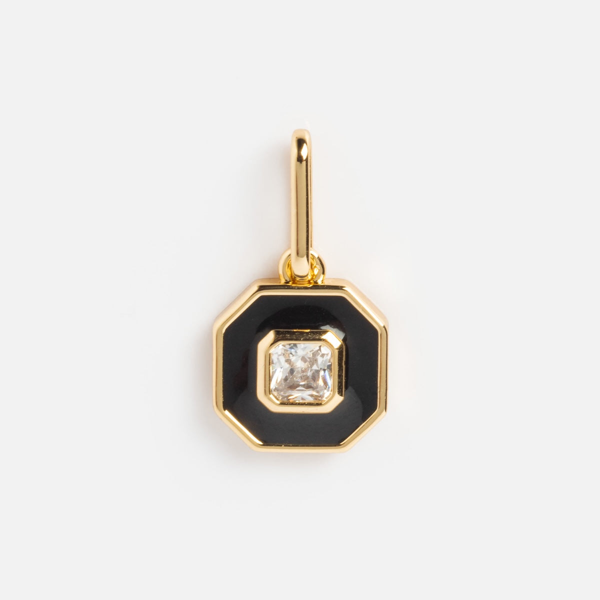 The Charms by Thatch pendant features a gold octagonal design with a black enamel border and a square-cut clear gemstone at the center, suspended from a gold loop. This elegant gold-plated charm is shown on a white background.
