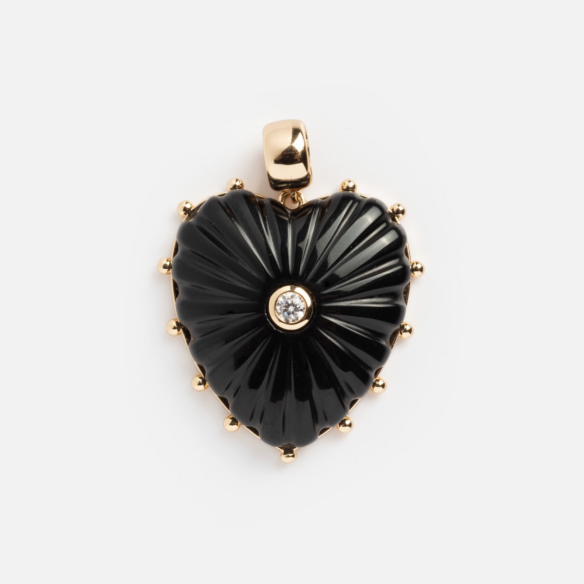 The Charms by Thatch features a heart-shaped black pendant with gold accents, fluted design, and central round white gemstone set on a gold bail, elegantly displayed on a plain white background.