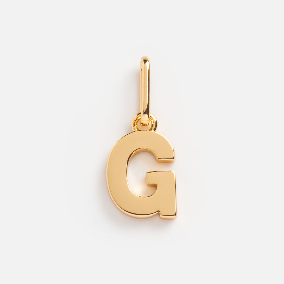 The Be You Initial Charm is a gold pendant in the shape of the letter G with a small loop at the top, ideal as an initial charm for a gold necklace or bracelet. It is displayed against a plain white background.