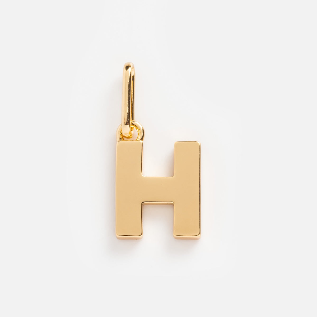 The Be You Initial Charm is a gold pendant shaped like a capital H with a top loop for attaching to your chain, ideal for personalized jewelry. Displayed on a plain white background.