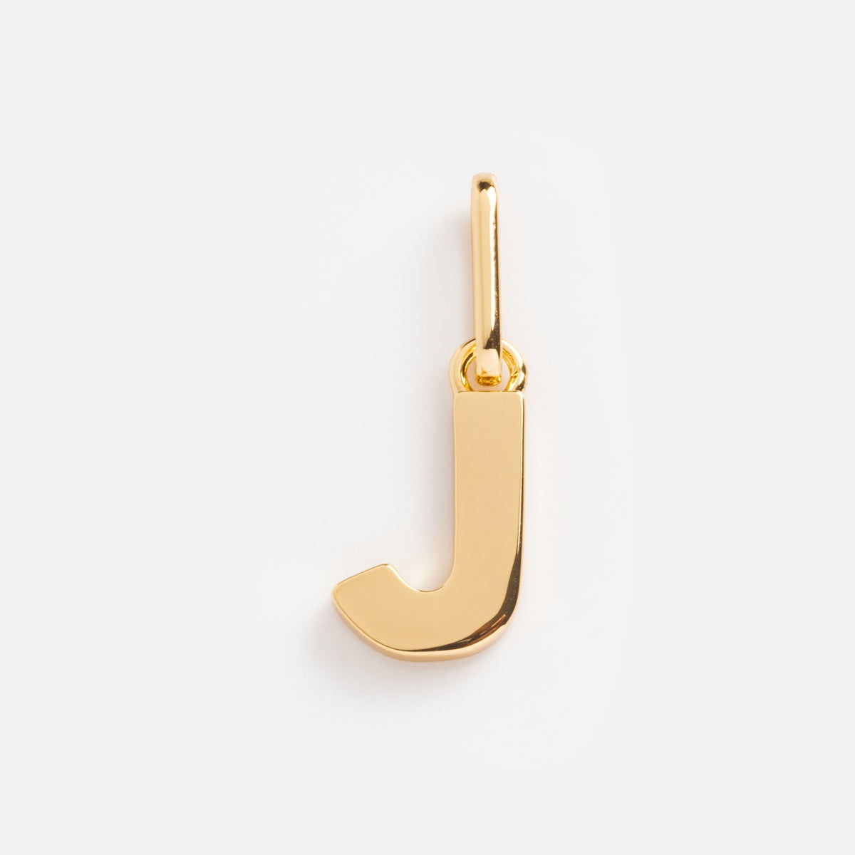 The Be You Initial Charm is a gold pendant shaped like the letter J, featuring a top loop for chain attachment—an ideal personalized jewelry piece shown on a plain white background.