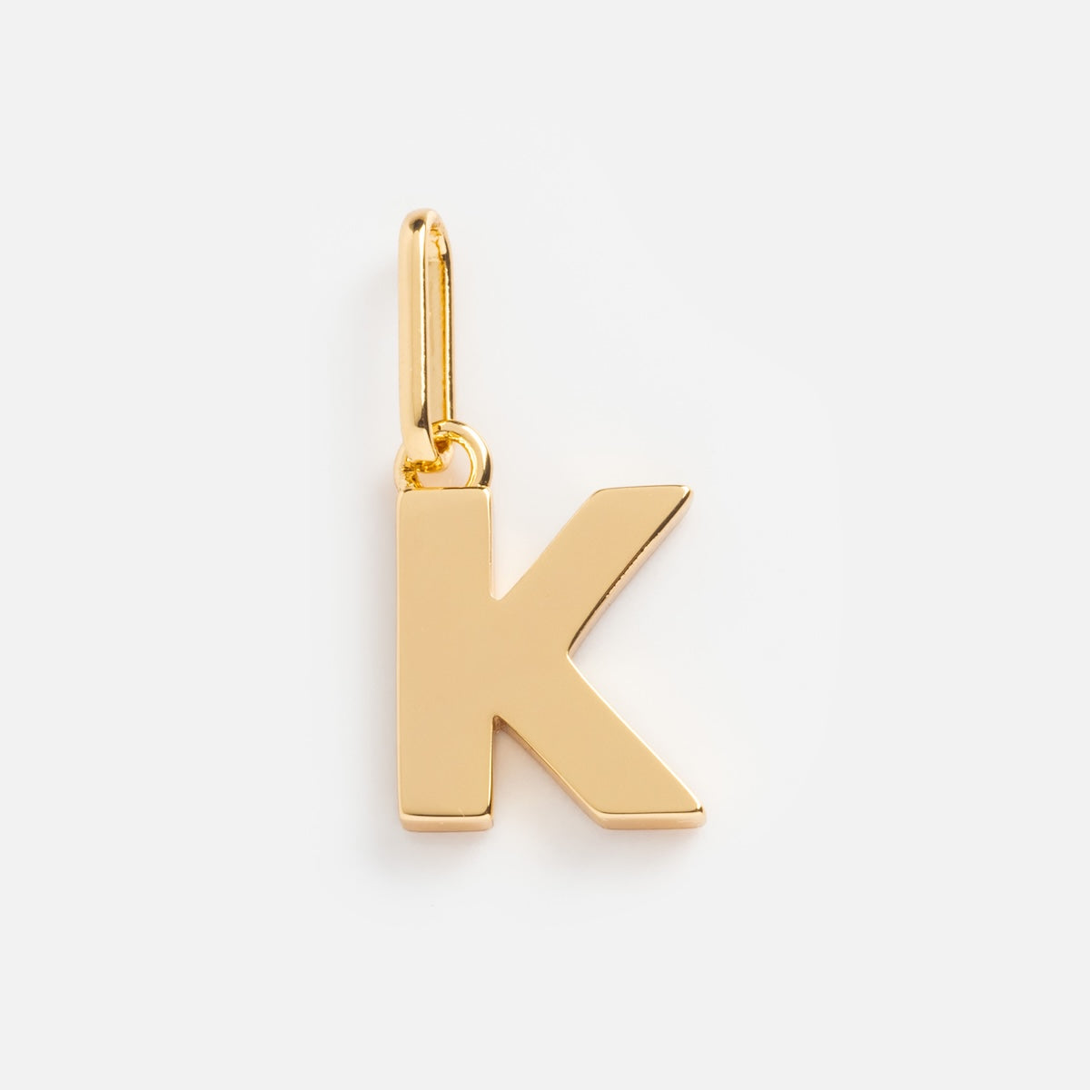 The Be You Initial Charm is a gold charm shaped like the letter K, with a polished finish and a top loop—ideal for adding personalized style to any gold necklace.