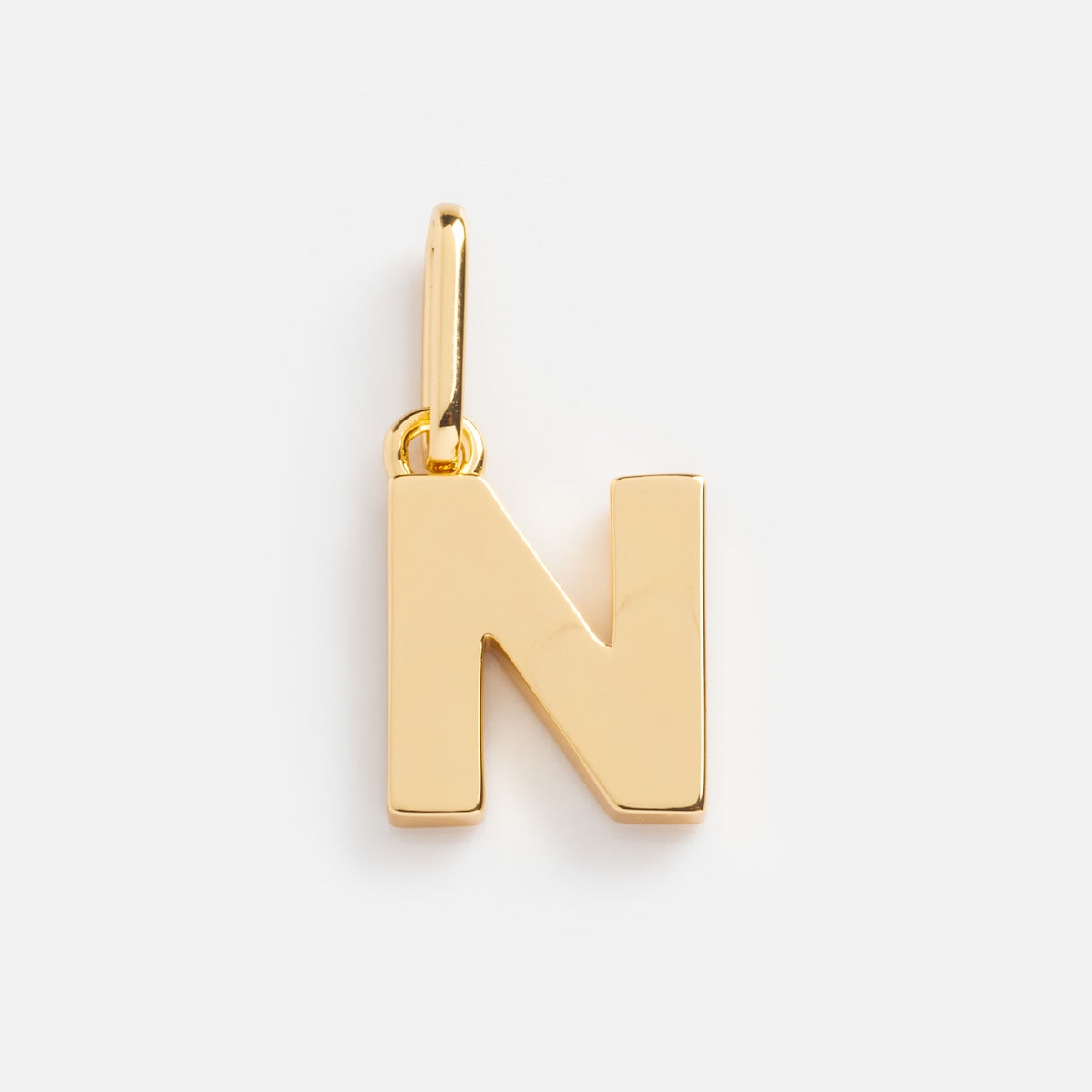 The Be You Initial Charm is a gold pendant in the shape of a capital N, featuring a small loop for attaching to a chain—ideal for personalized jewelry lovers. Shown against a plain white background.
