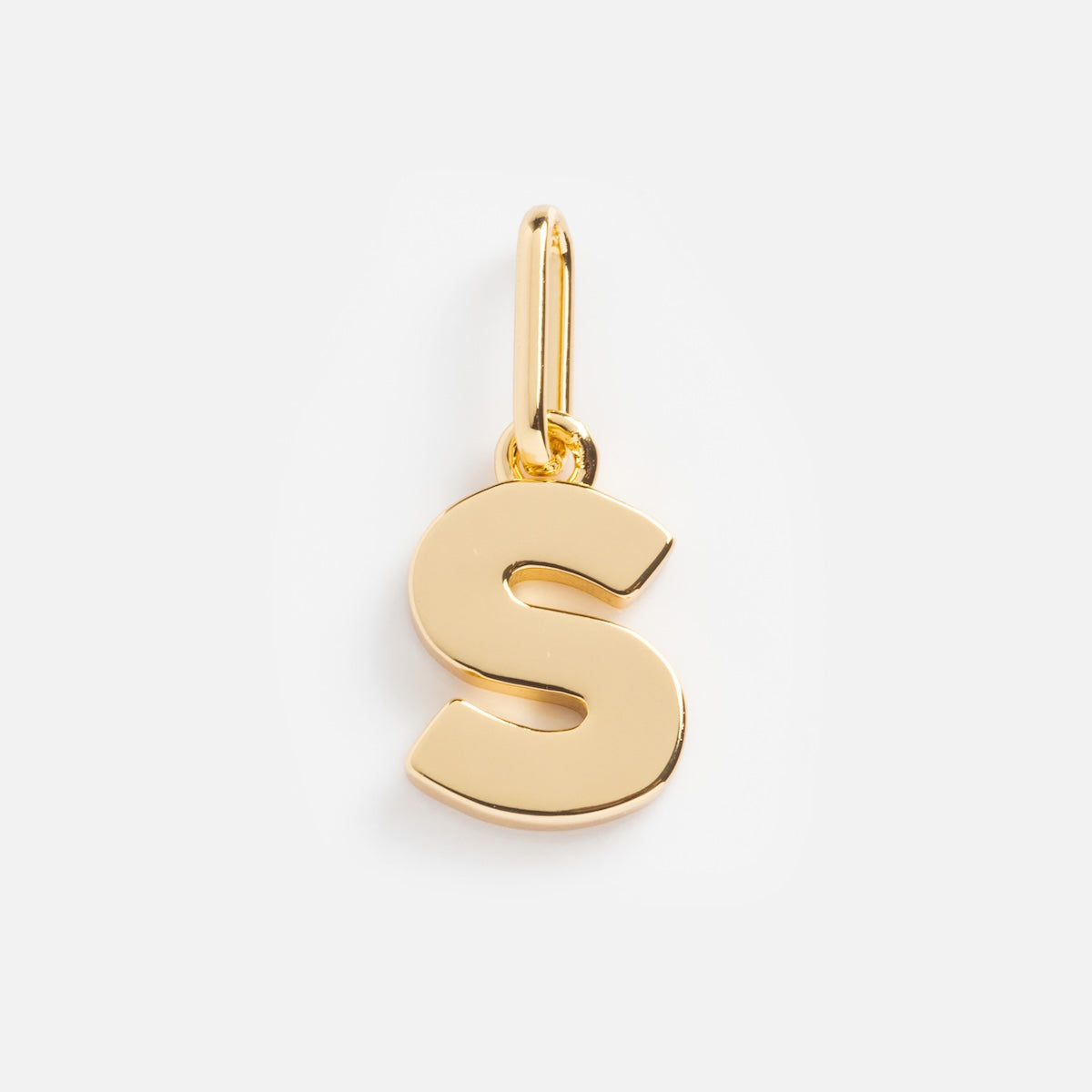 The Be You Initial Charm is a gold pendant shaped like the letter S, featuring a smooth polished finish and a top loop for attaching to a necklace or bracelet, shown on a white background.
