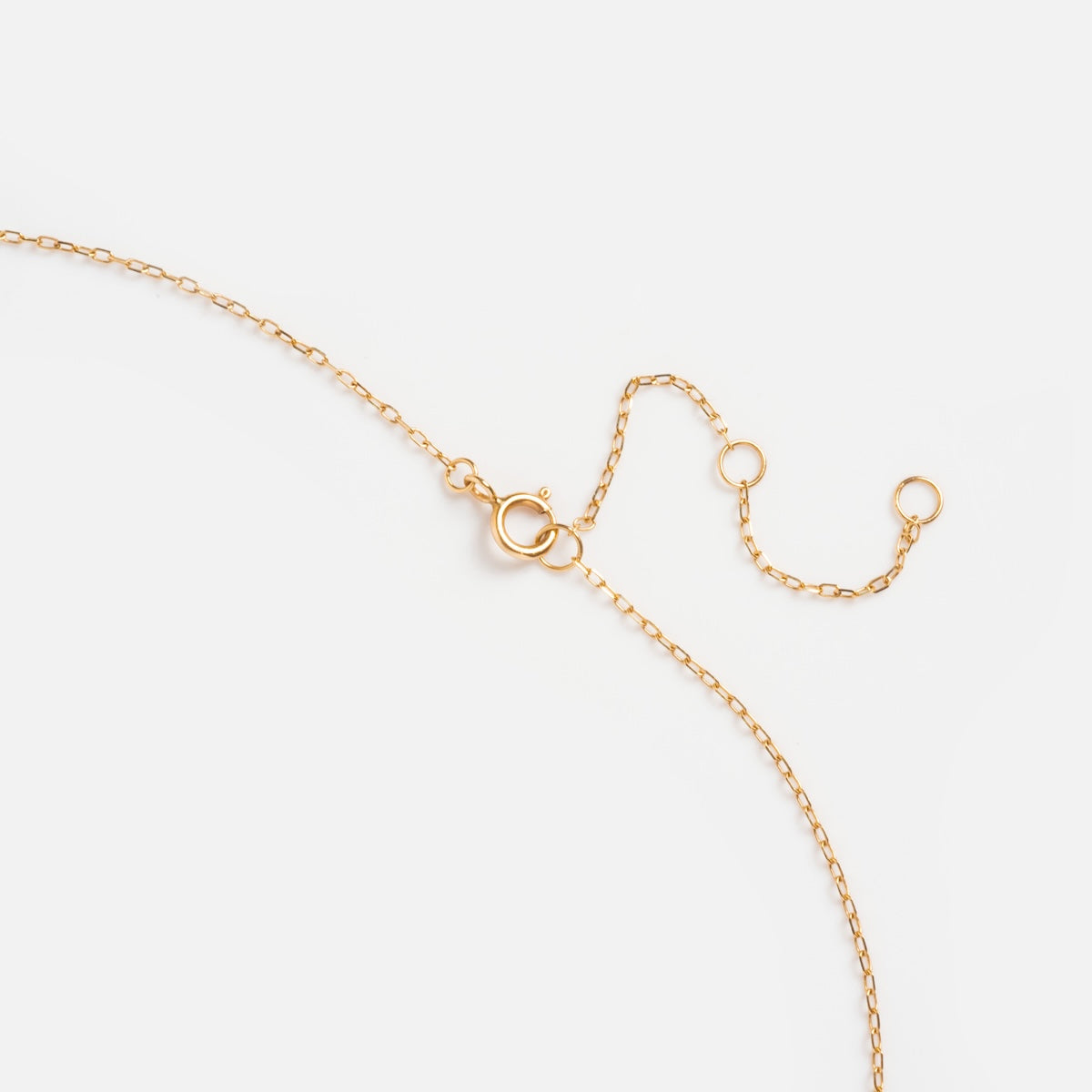 The Solid Gold Evil Eye Necklace is a delicate 9k yellow gold chain with a spring ring clasp and two extension rings, shown on a plain white background.