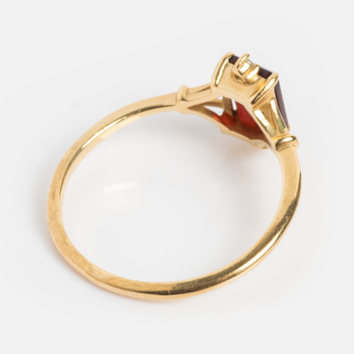 The Solid Gold 2025 January Capsule Classic Garnet Statement Ring features a thin band and raised prong-set red garnet, viewed at an angle on a white background—an elegant birthstone ring for January.