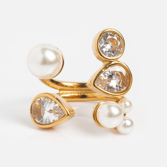 The Pearl and Clear Wrap Ring features two large and three small pearls, clear gemstones in various shapes, all set on intertwining 18k yellow gold plated bands against a white background.