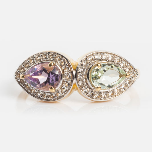 The 14k Pastel Amethyst Toi et Moi Ring in gold showcases two pear-shaped gemstones—purple and pale green—each with a halo of clear stones, set side by side for a refined, modern heirloom look.