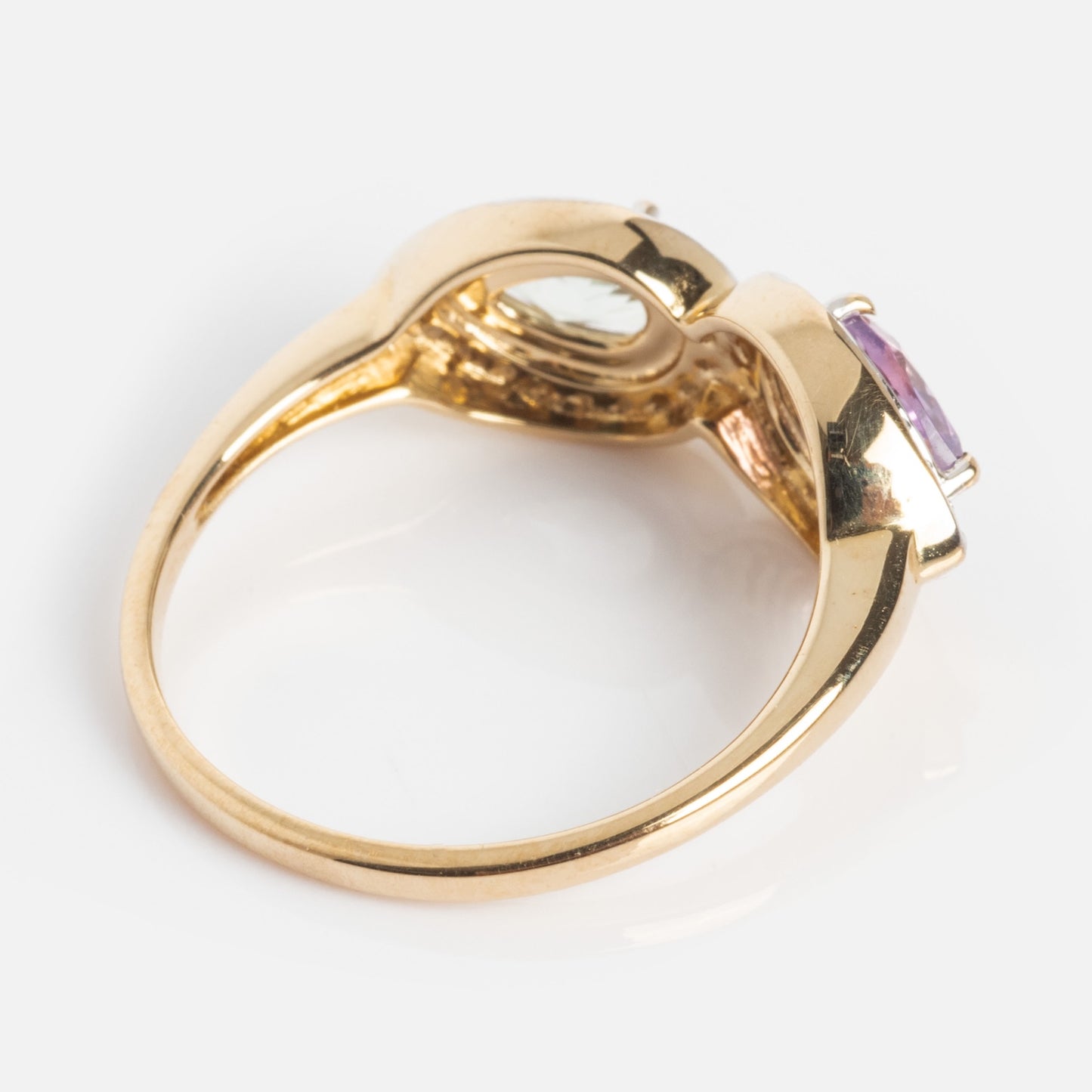 The 14k Pastel Amethyst Toi et Moi Ring showcases a central oval purple gemstone, its band and setting underside visible from an angled view against a white background.
