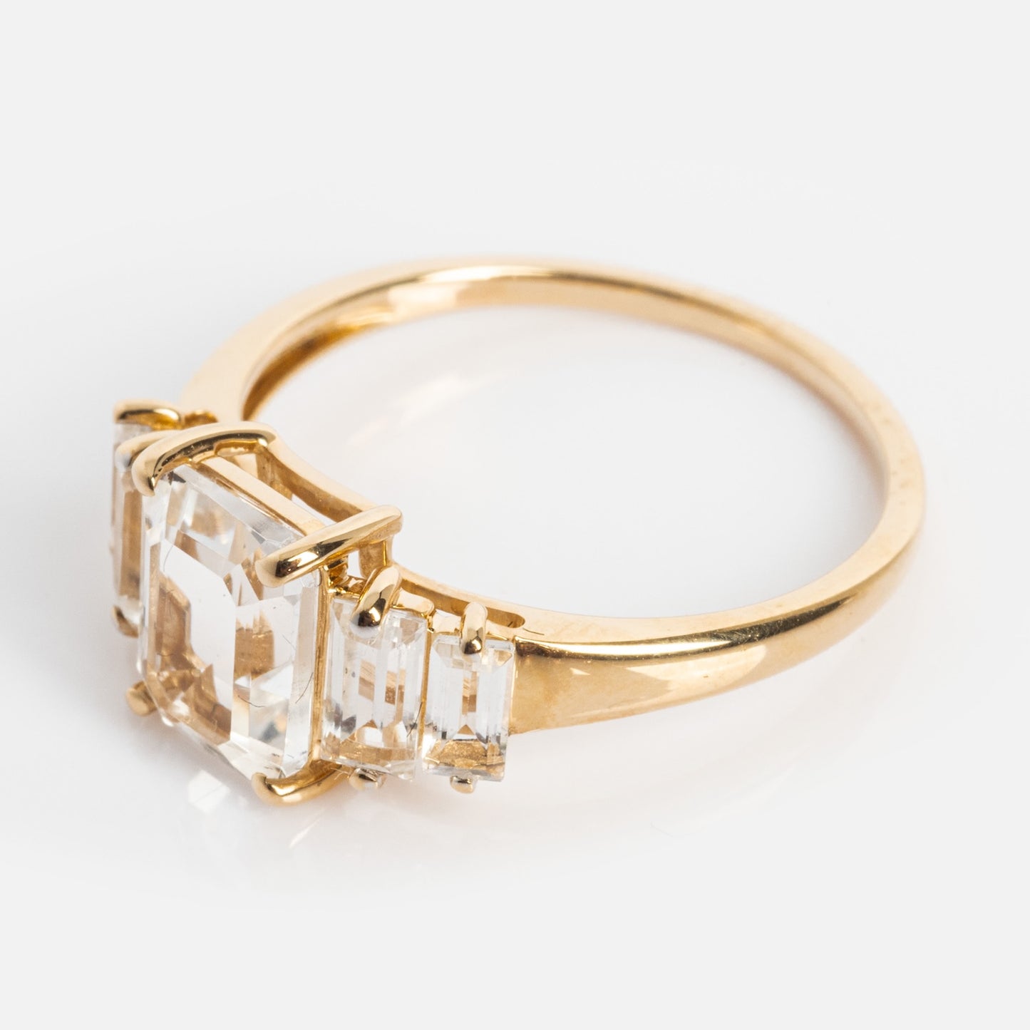 The 14k Graduated White Topaz Engagement Ring showcases a large, step-cut white topaz in solid gold for timeless elegance.