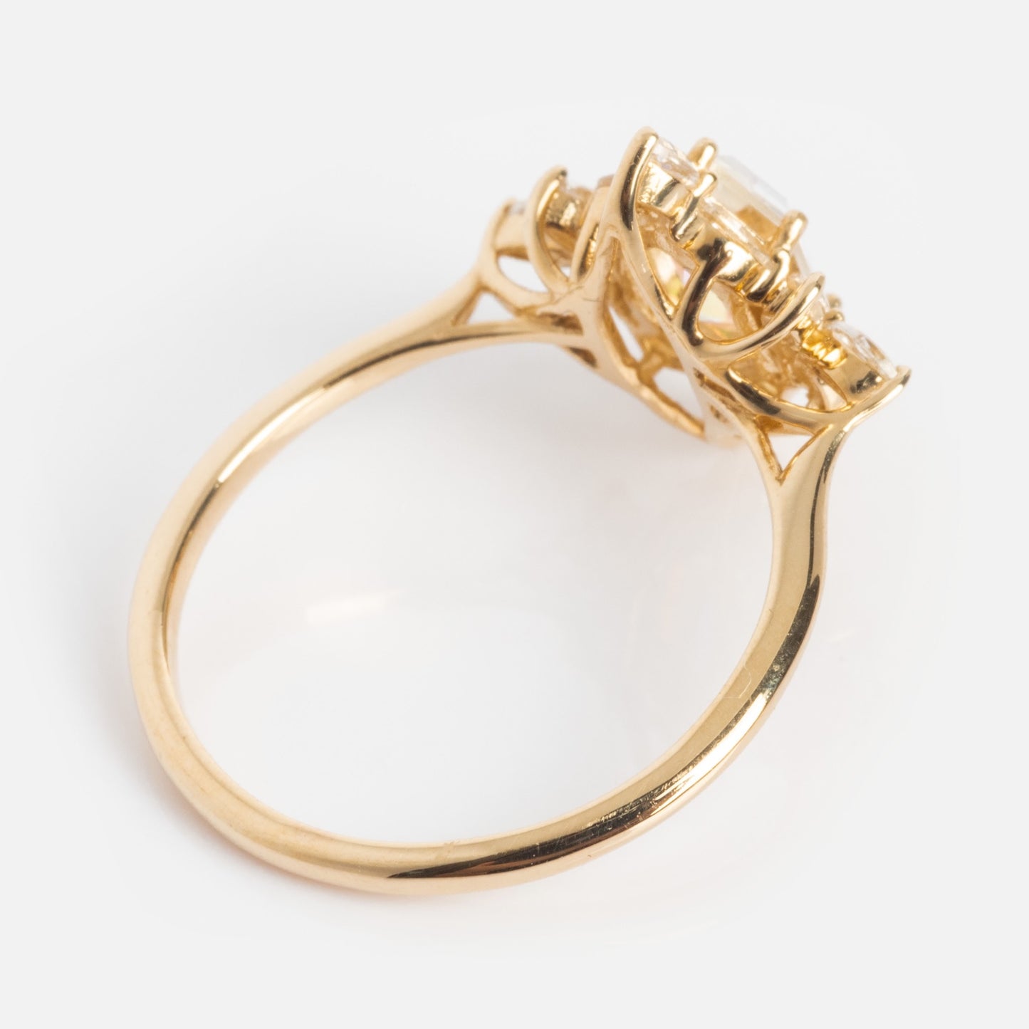 The 14k Angel Aura Quartz Splendor Statement Ring features an intricate gold band with a raised setting holding multiple clear gemstones, showcased on a plain white background.