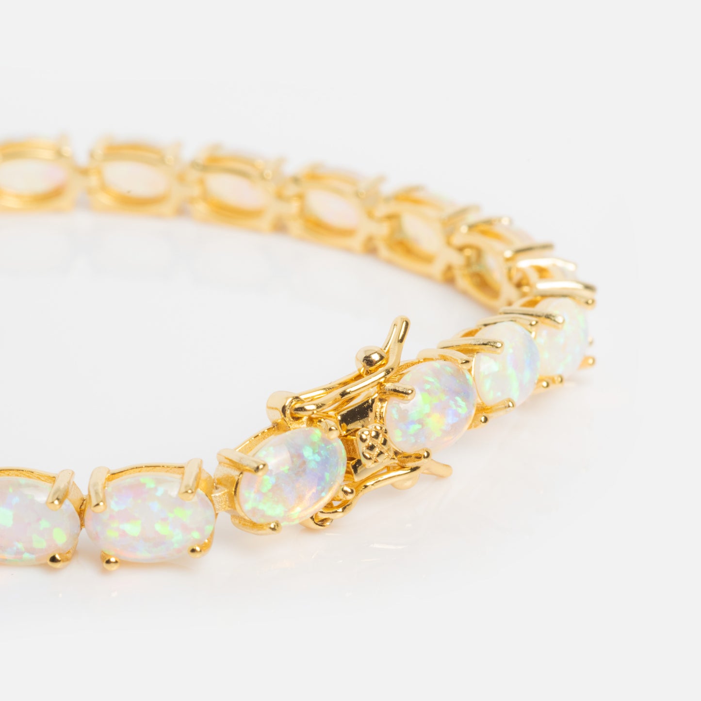 The Eternal Blue Opal Tennis Bracelet is a gold vermeil piece featuring oval lab-created opals in gold settings, shown on a white background.