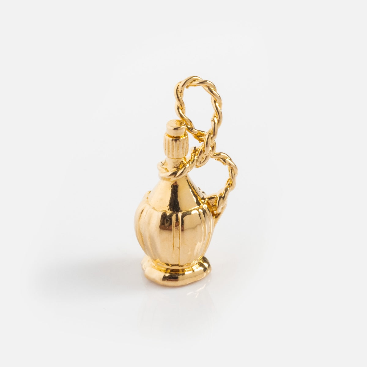 The Charms by I Like It Here Club is a small, vintage perfume bottle-shaped charm with a decorative twisted handle, crafted with 12k yellow gold plating, shown on a plain white background.