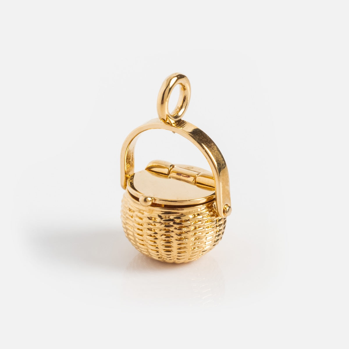 The Charms by I Like It Here Club features a small basket-shaped charm with a hinged lid, loop handle, and 12k yellow gold plating—perfect for adding personalized style to any bracelet or necklace. Shown on a plain white background.