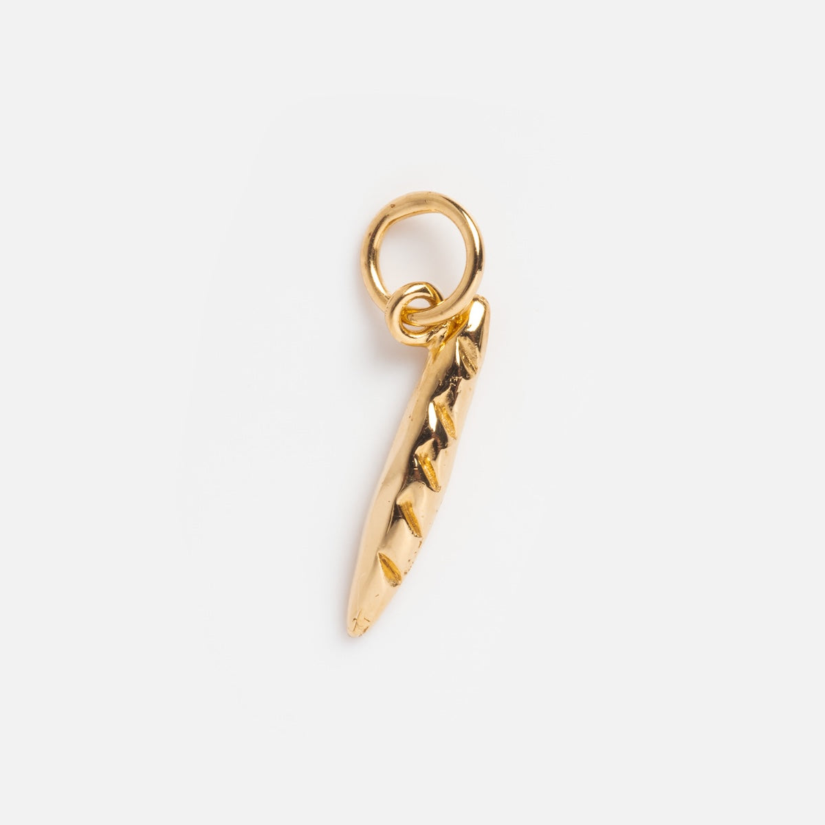 The Charms by I Like It Here Club is a small, baguette-shaped charm with textured details, 12k yellow gold plating, and an attached circular loop for hanging, displayed on a plain white background.