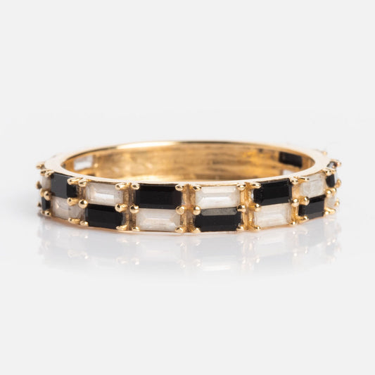 The Solid Gold Black and White Checkerboard Band displays alternating rectangular black agate and white topaz stones in a continuous pattern around the ring, shown against a white background.