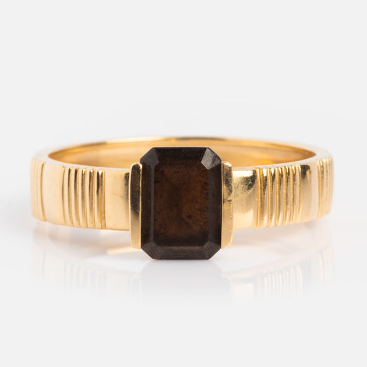 The Solid Gold Vintage Inspired Bold Black and Gold Ring features a rectangular dark brown smoky quartz centerpiece and engraved vertical lines, creating a refined art deco look.