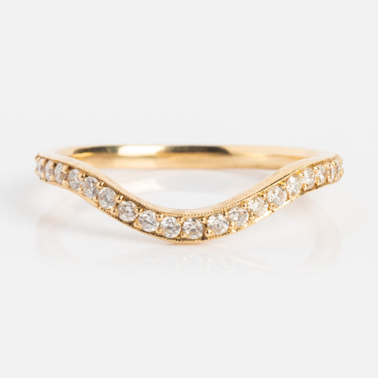 The 14k Low Tide Curved Band with Diamonds features a gentle curved shape and a sparkling row of round diamonds—perfect as a delicate diamond stacking ring.