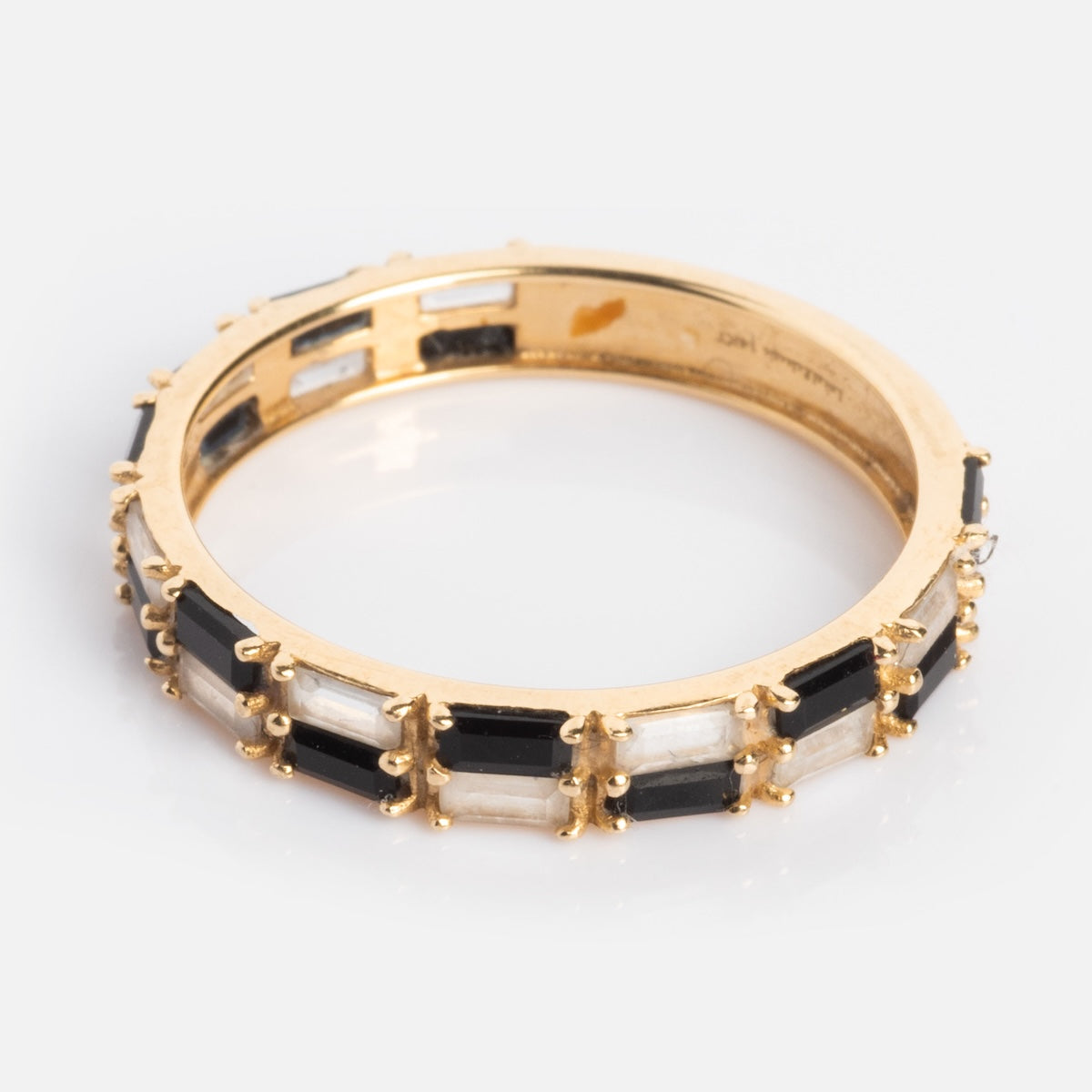 The Solid Gold Black and White Checkerboard Band features alternating rectangular black agate and white topaz gemstones set with delicate prongs, presented on a plain white background.