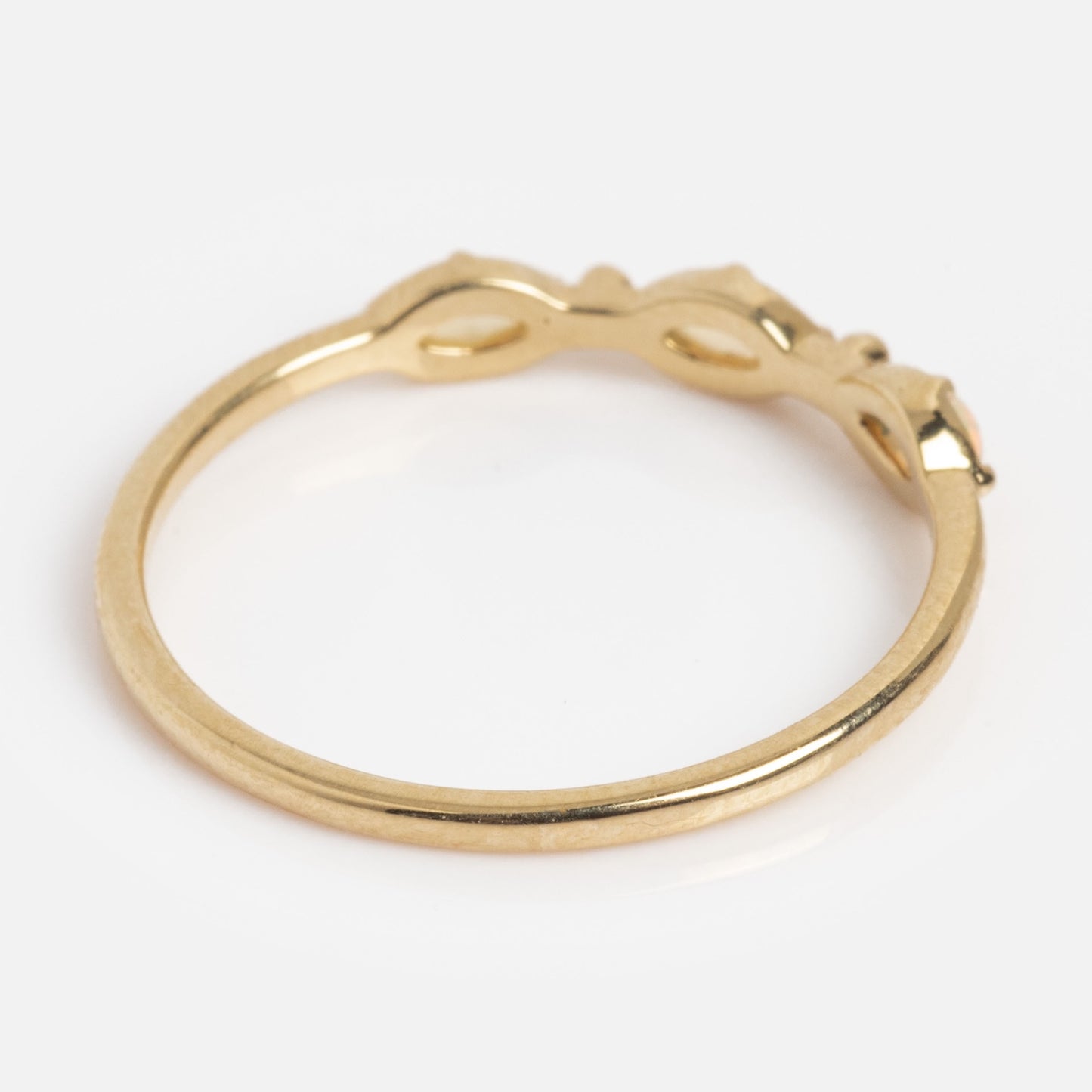 The Solid Gold Dainty Opal Trio Stacking Ring features a trio of opals set in a delicate gold band, shown on a white background.