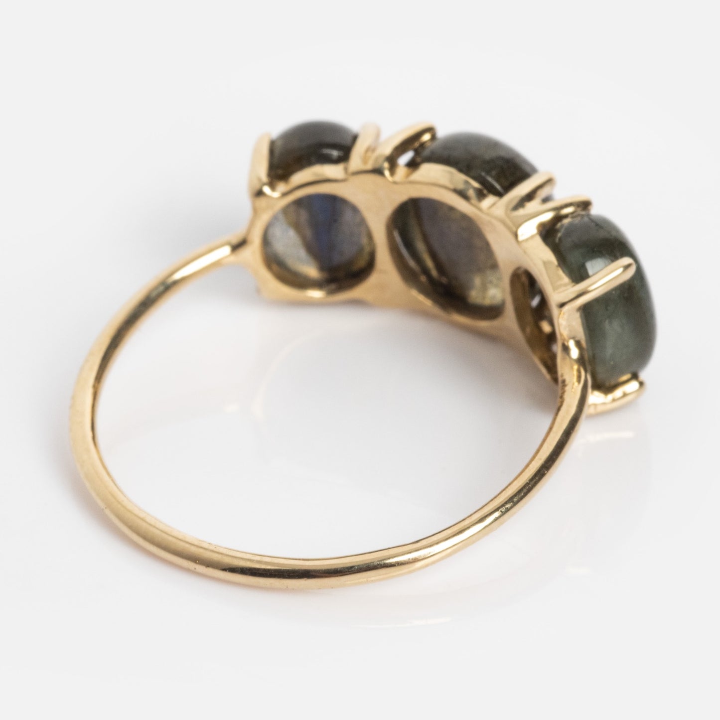 The Sweetest Gumdrop Ring, crafted in solid yellow gold, features three oval dark natural gemstones in prong settings, shown from the side to showcase its exquisite band and setting details against a white background.
