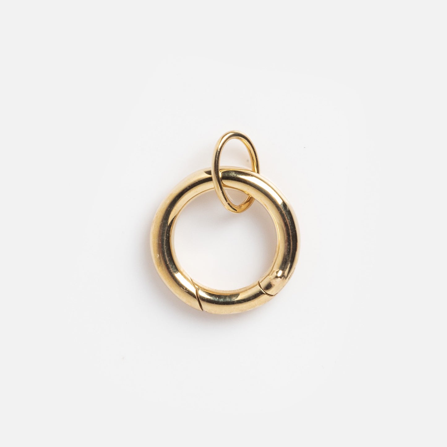 The Solid Gold Charm Clip is a shiny, circular accessory with a small top loop, ideal for attaching to bracelets, shown isolated on a plain white background.