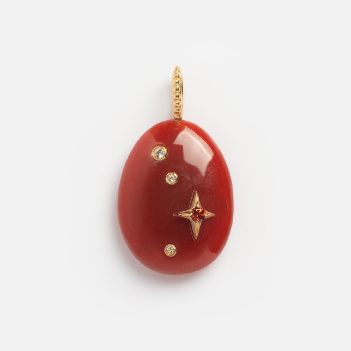 The Solid Gold Zodiac Constellation Crystal Charm features a red oval pendant with three round diamonds and a gold star-shaped setting with a central red gemstone, all attached to a gleaming gold loop for stunning personalized zodiac jewelry.
