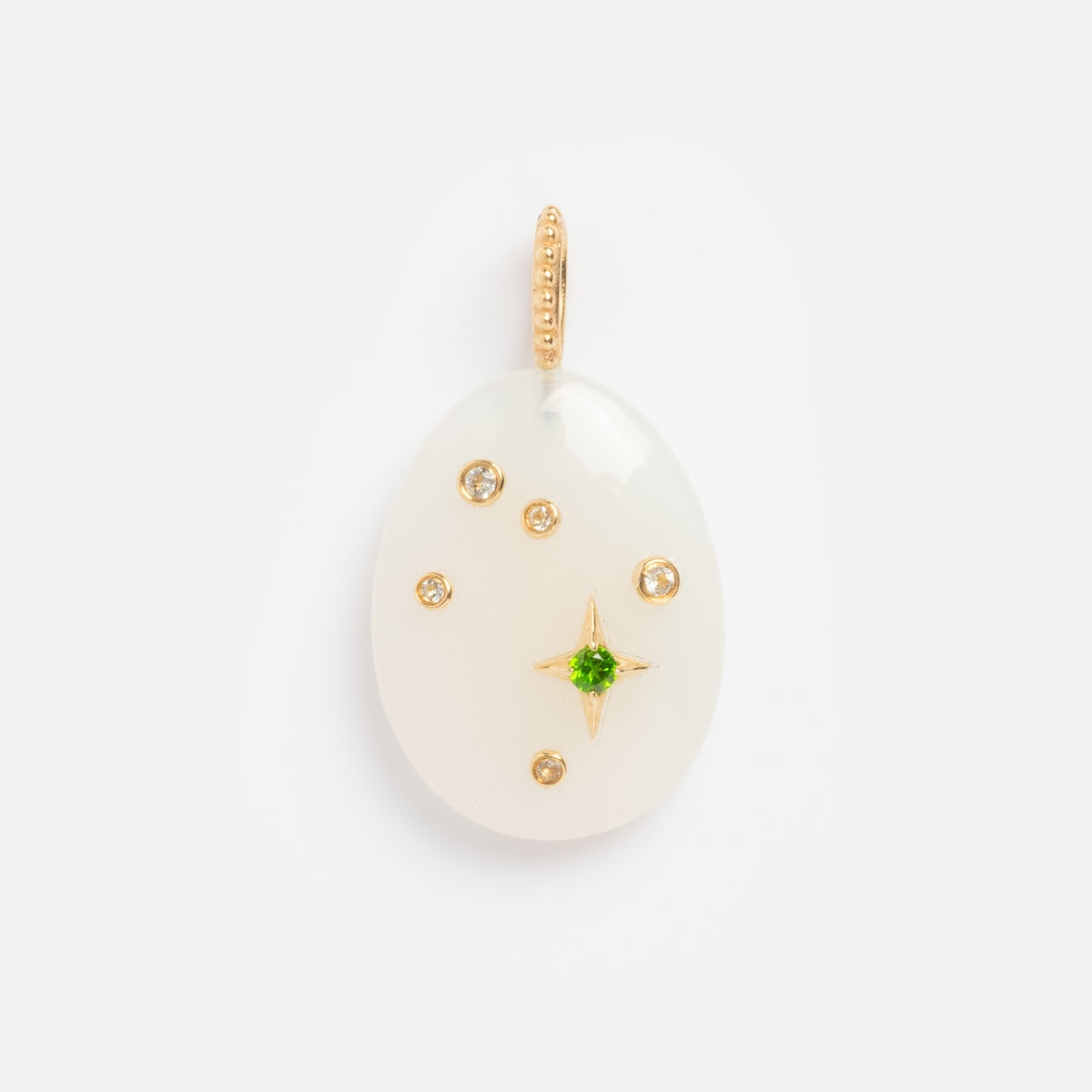 The Solid Gold Zodiac Constellation Crystal Charm features an oval white pendant with gold accents, a central green gem, starburst design, and a gold beaded loop—ideal for adding to your personalized zodiac jewelry collection.