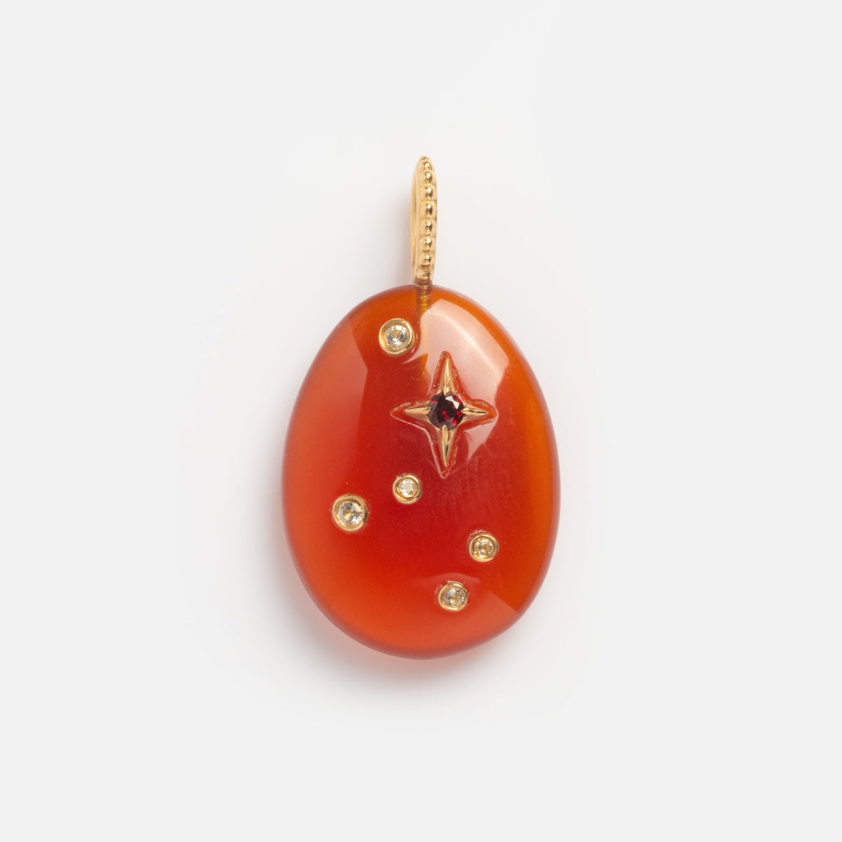 The Solid Gold Zodiac Constellation Crystal Charm is an oval red-orange pendant with a gold bail, adorned with a star-shaped zodiac constellation and five small round gemstones, displayed on a plain white background.
