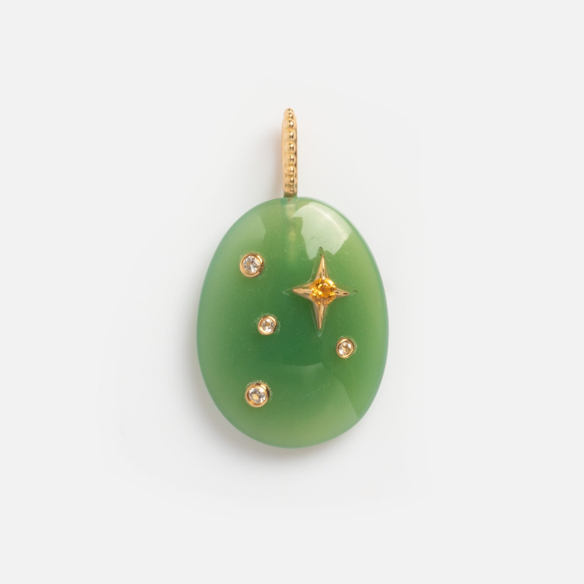 The Solid Gold Zodiac Constellation Crystal Charm is an oval green pendant with a gold loop, featuring four gold studs and a central gold star-shaped accent, photographed on a plain white background.