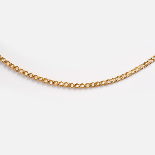 The Tennis Necklace in Pearl is a 14k yellow gold piece with circular links, each accented by a small white pearl, shown against a plain white background.