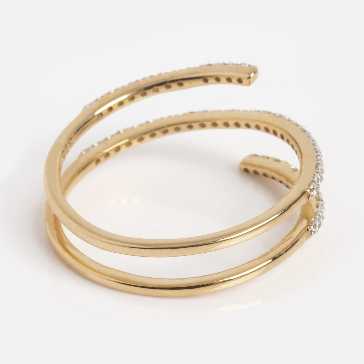 The Solid Gold Shifting Shimmer Diamond Wrap Ring features two overlapping gold bands, one embellished with shimmering diamonds, displayed against a plain white background.