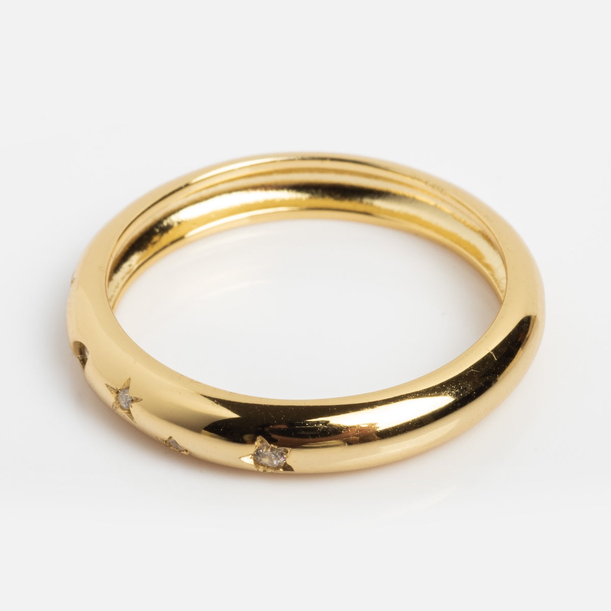 The Star Crossed Celestial Dome Ring features a shiny gold dome with a smooth, rounded surface and small CZ stars set with tiny diamonds, shown against a white background.