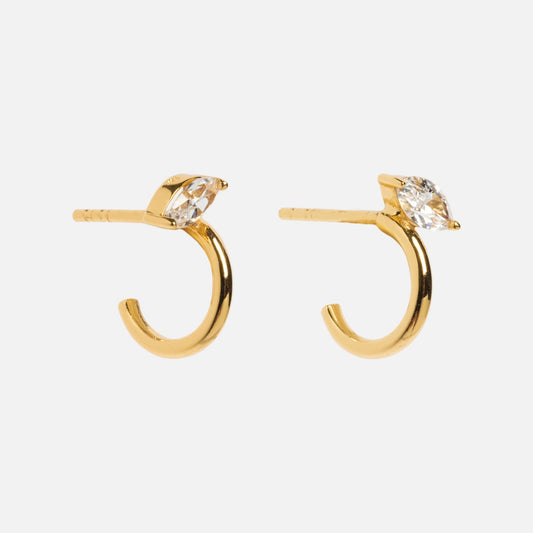 The Clear Illusion Stud Huggies are 18k yellow gold earrings with a small open hoop design and a marquise-cut clear CZ gemstone at the top, shown against a plain white background.