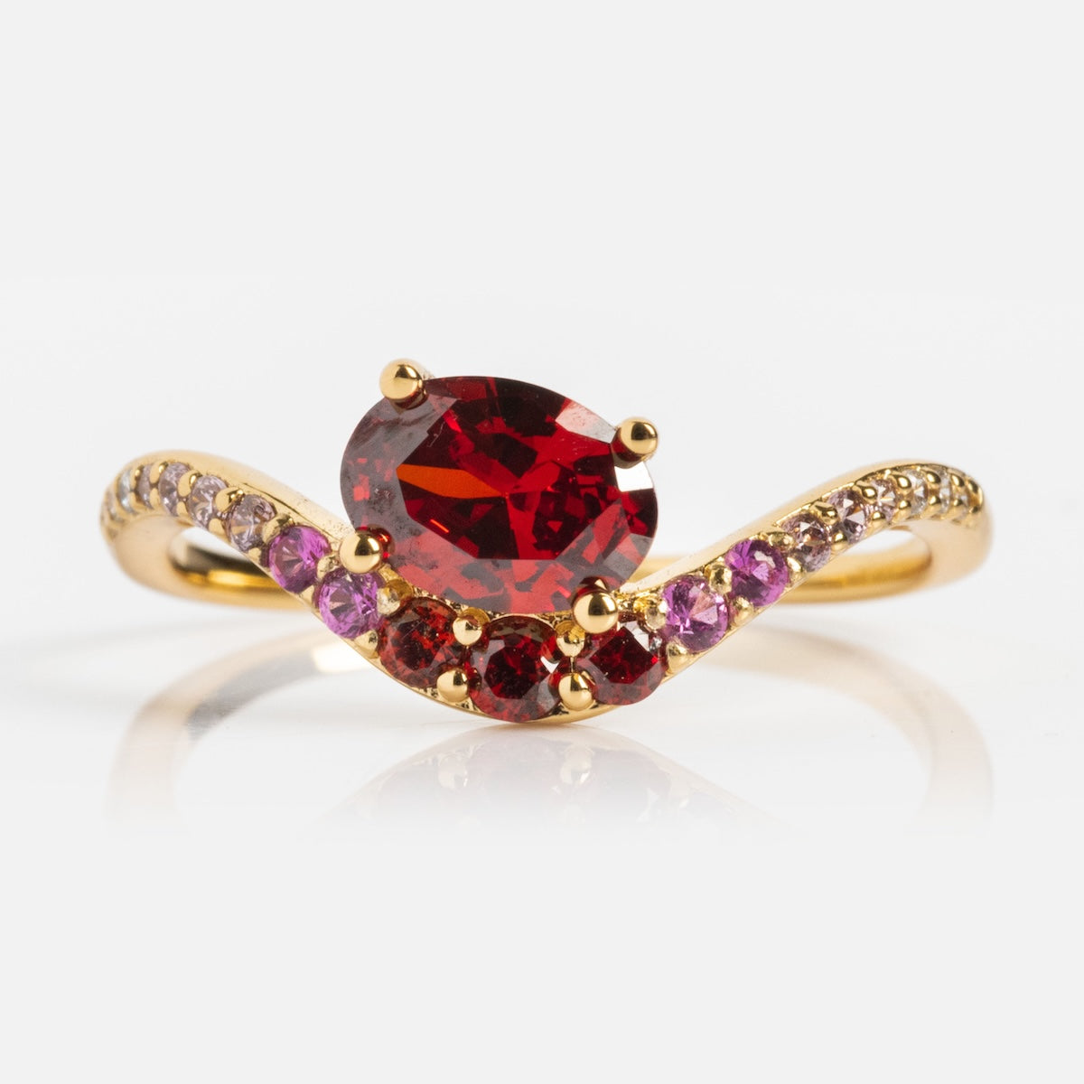 The Main Character Floating Ombre Birthstone Ring features a large oval red center gemstone, accented by smaller pink and red stones that elegantly curve along the gold ombre band.