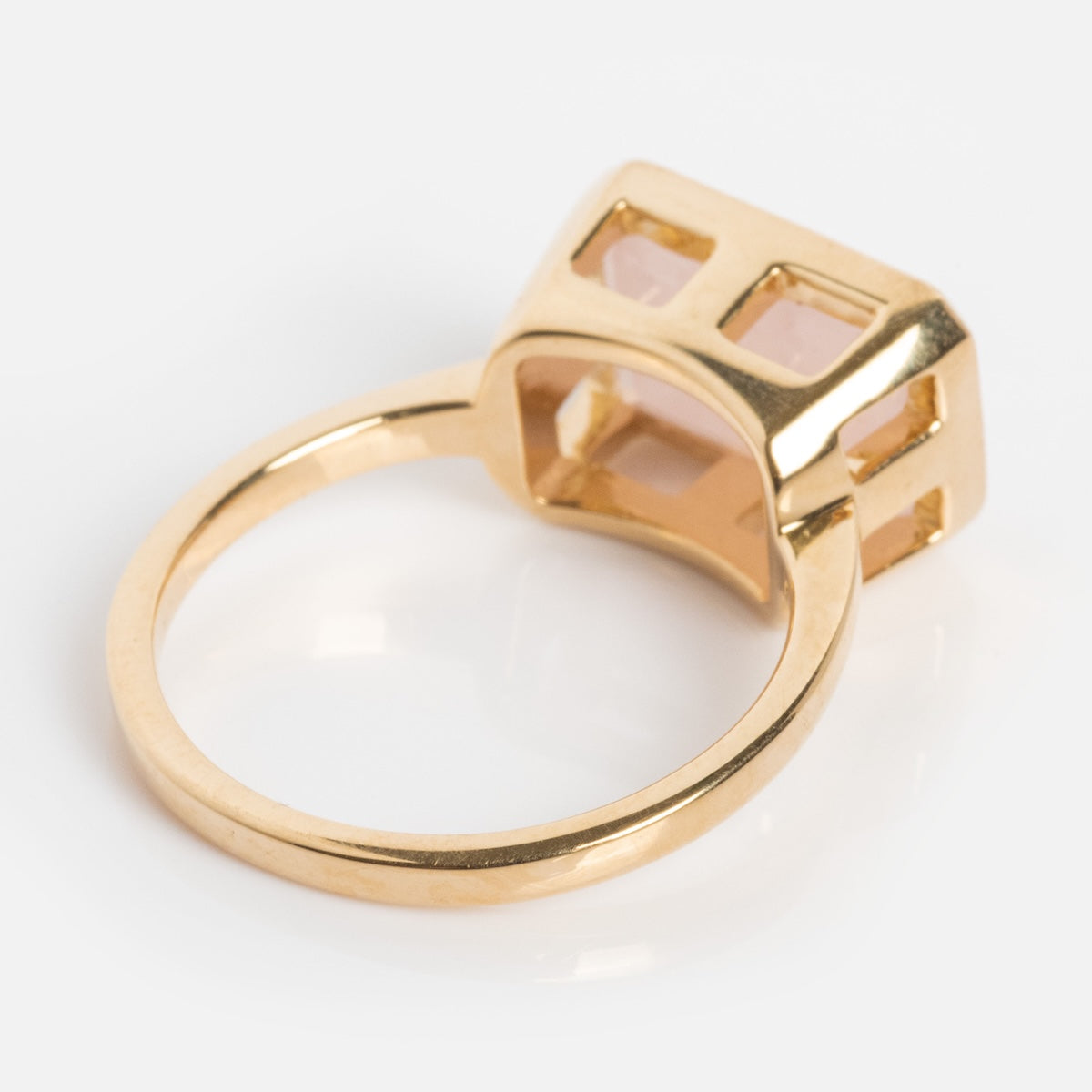 A modern heirloom, the 14k Jojo Ring features a large rectangular setting with multiple pale pink gemstones in an open geometric design, all crafted in solid yellow gold and displayed on a white background.