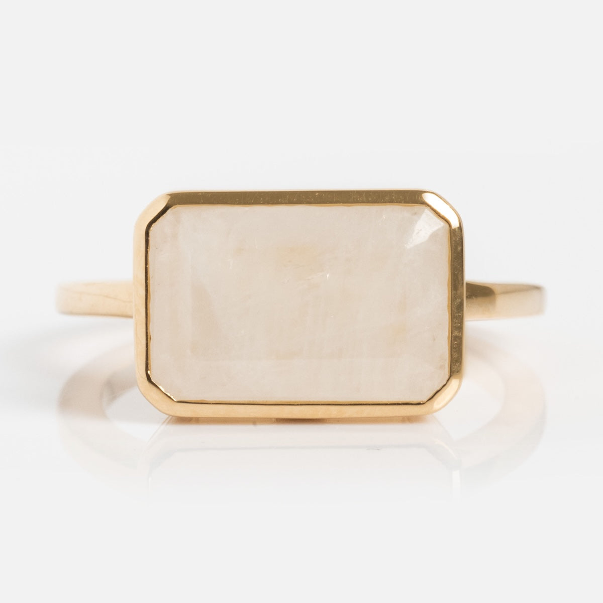 The 14k Jojo Ring is made of solid yellow gold and features a rectangular, light-colored stone with beveled edges set in a minimalist band, shown on a plain white background.