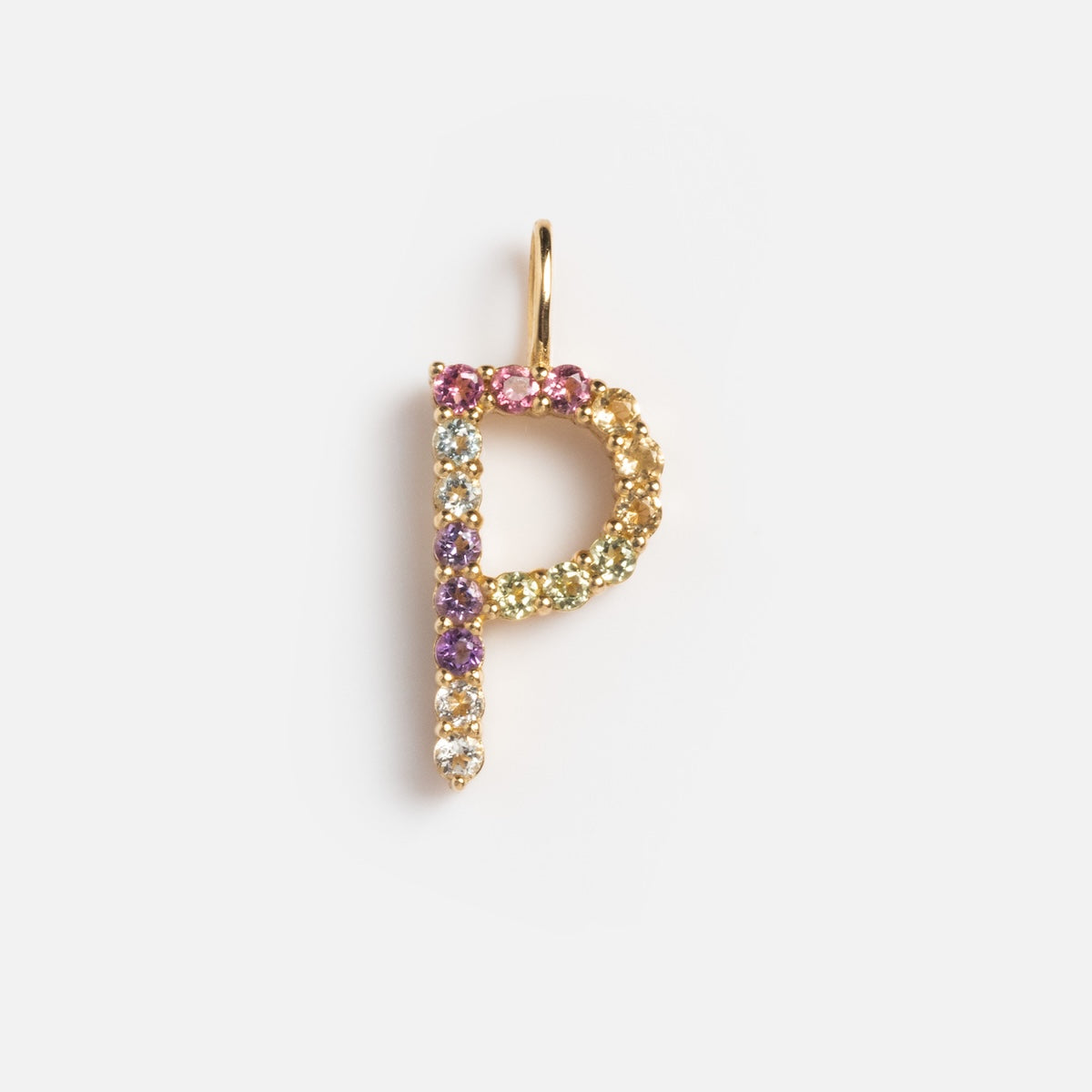 The Solid Gold Pastel Gemstone Letter Charm Sample features a P-shaped pendant in 9k yellow gold, embellished with pink tourmaline and purple, green, and clear gemstones, shown on a plain white background.