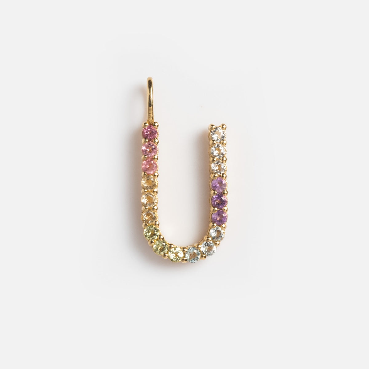 The Solid Gold Pastel Gemstone Letter Charm Sample is a 9k yellow gold U-shaped pendant adorned with pink tourmaline and pastel gemstones in yellow, green, purple, and clear tones, shown on a plain white background.